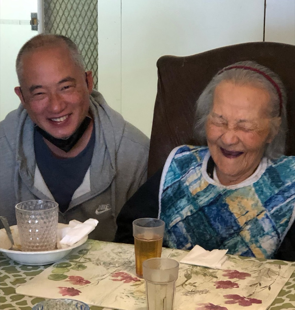 A caregiver sharing a laugh with a resident at Janet's